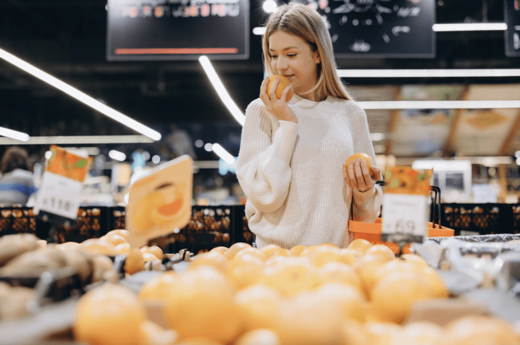 Customer,Choosing,Oranges,At,Supermarket,Fruit,And,Vegetable,Section,,Smelling - welltica.dk - Vejen til et bedre liv appelsiner