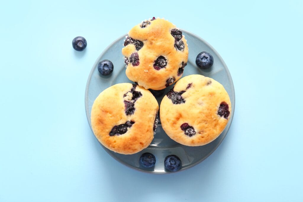 Plate,With,Tasty,Blueberry,Muffins,On,Blue,Background - welltica.dk - Vejen til et bedre liv