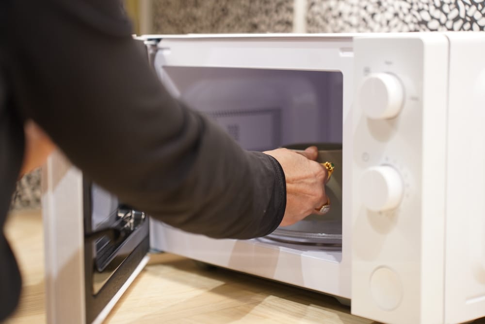 Cropped,Image,,Rear,View,Of,Woman,Using,Microwave,Oven,To - welltica.dk - Vejen til et bedre liv