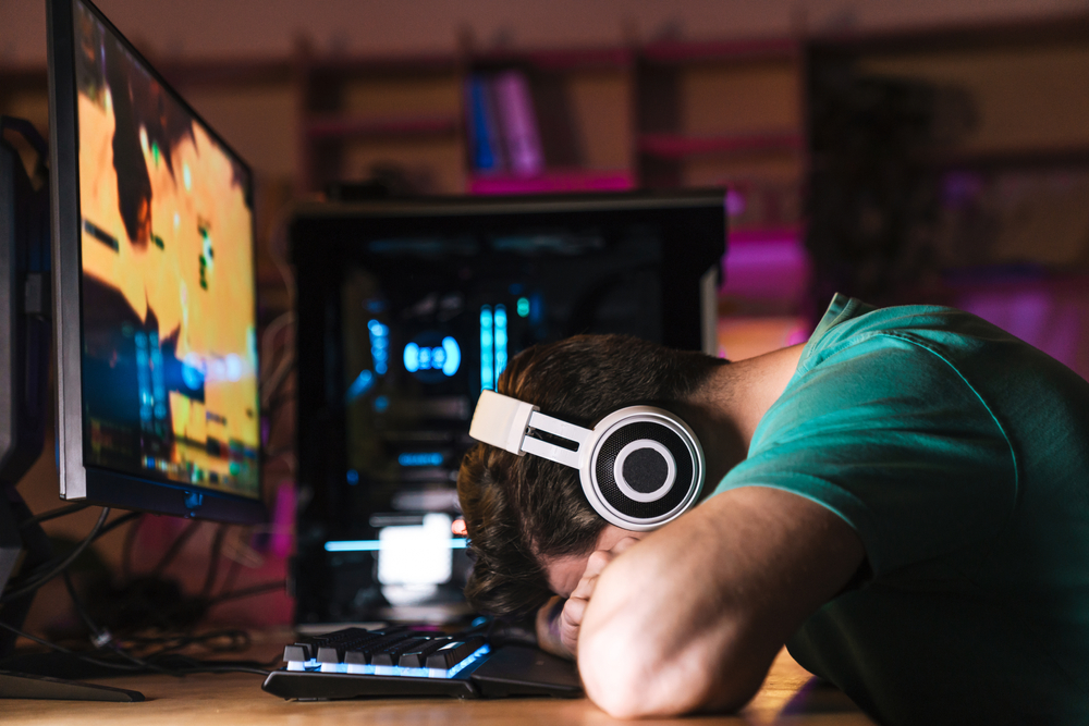 Image,Of,Exhausted,Young,Man,In,Headphones,Sleeping,While,Playing - welltica.dk - Vejen til et bedre liv