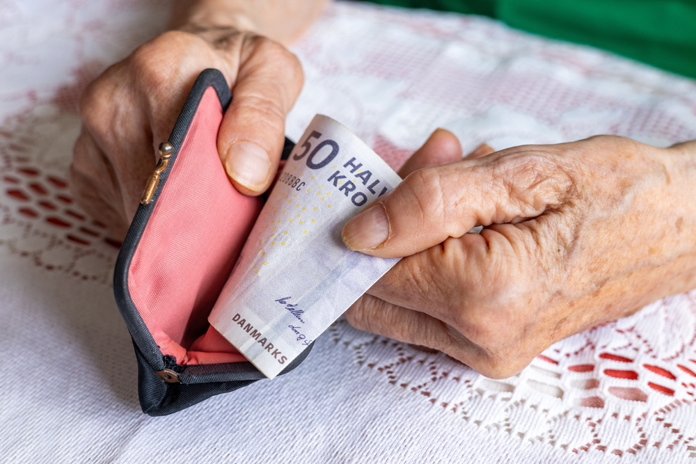 Denmark,Money.,An,Elderly,Woman,Takes,Out,50,Danish,Kroner - welltica.dk - Vejen til et bedre liv