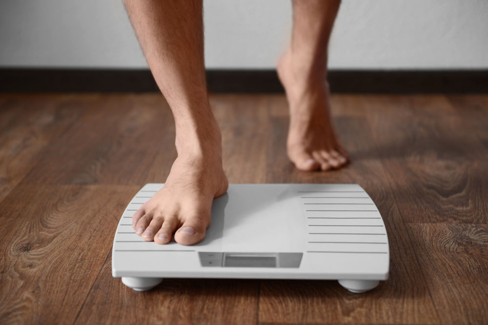 Man,Standing,On,Weight,Scale - welltica.dk - Vejen til et bedre liv