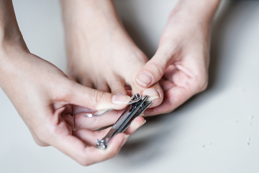 YoungWomancuttingHerFootFingernail - welltica.dk - Vejen til et bedre liv