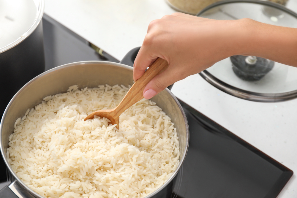 Woman,Cooking,Rice,On,Stove,In,Kitchen,,Closeup - welltica.dk - Vejen til et bedre liv