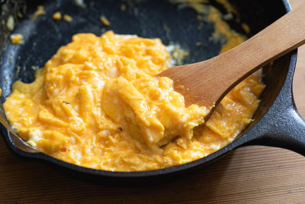 ScrambledEggsCookedInAnCastIronSkilletWoodenSpatula - welltica.dk - Vejen til et bedre liv