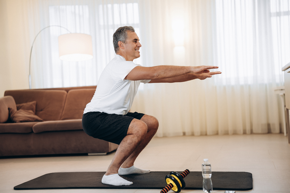 WorkoutTimeStrongSeniorManDoingSquatExercisesAtHome - welltica.dk - Vejen til et bedre liv