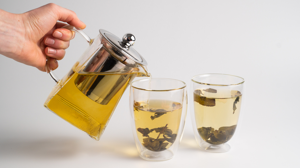 OolongLeavesTeaInATeacupOnWhiteBackgroundPouring - welltica.dk - Vejen til et bedre liv
