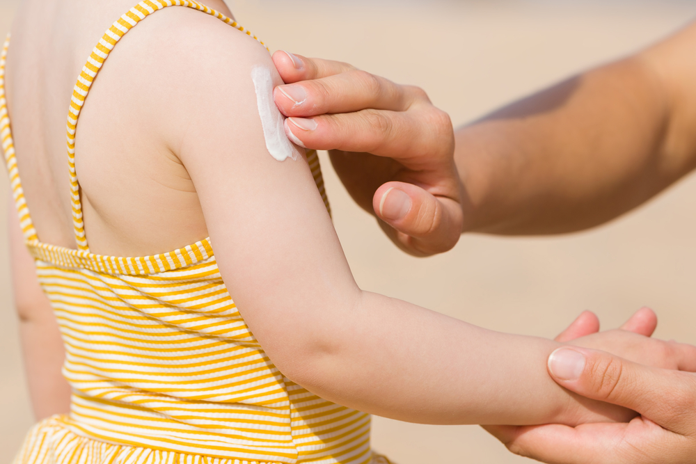 YoungMotherHandApplyingSunscreenLotionOnLittleGirlShoulder - welltica.dk - Vejen til et bedre liv