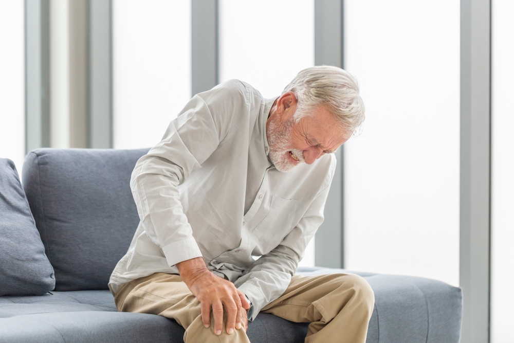 OldManSufferingFromKneePainSittingSofaInThe - welltica.dk - Vejen til et bedre liv