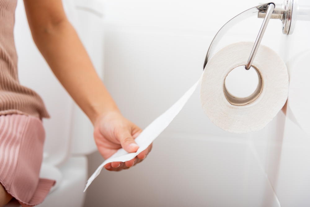 CloseupHandPullingToiletPaperRollInHolderForWipe - welltica.dk - Vejen til et bedre liv
