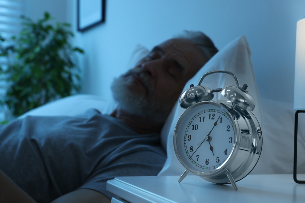 SeniorManSleepingInBedAtHomeFocusOnAlarm - welltica.dk - Vejen til et bedre liv