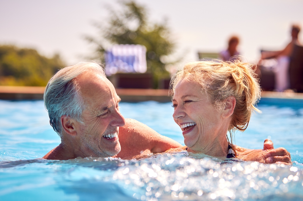 RetiredSeniorCoupleRelaxingInSwimmingPoolOnSummerVacation - welltica.dk - Vejen til et bedre liv