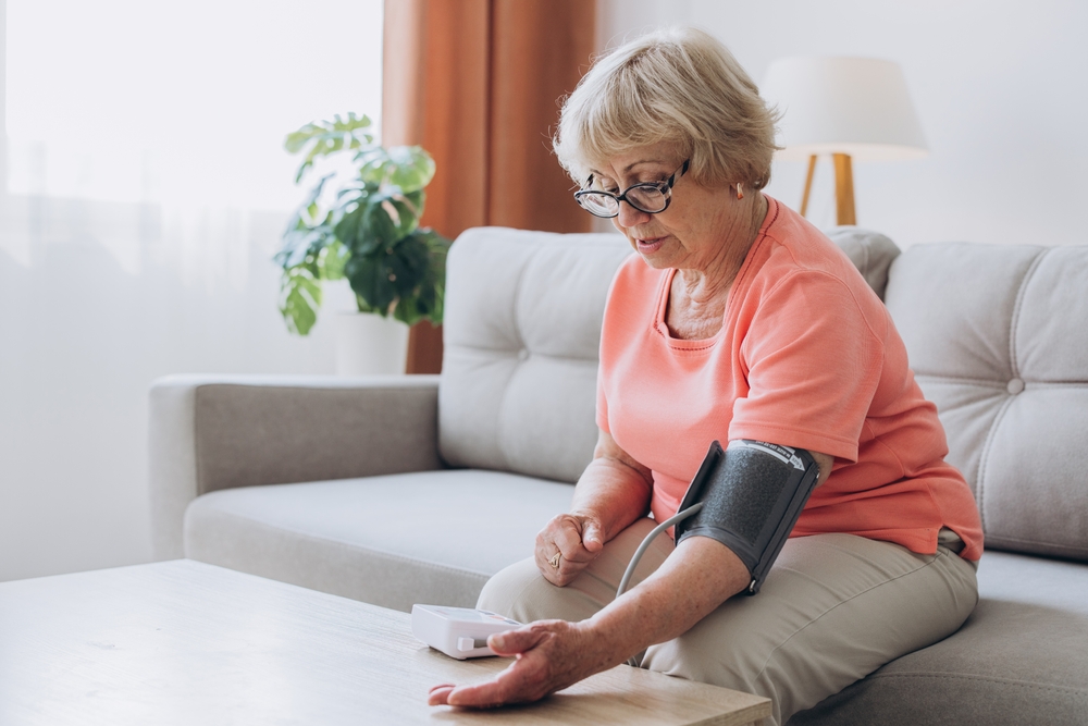 SeniorWomanWithHypertensionMeasuringBloodPressureHerselfAtHome - welltica.dk - Vejen til et bedre liv