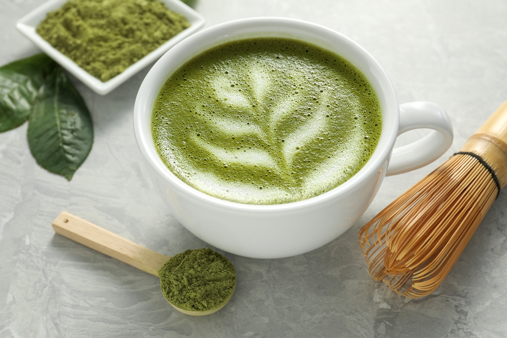 CupOfFreshMatchaLattePowderAndBambooWhiskOn - welltica.dk - Vejen til et bedre liv