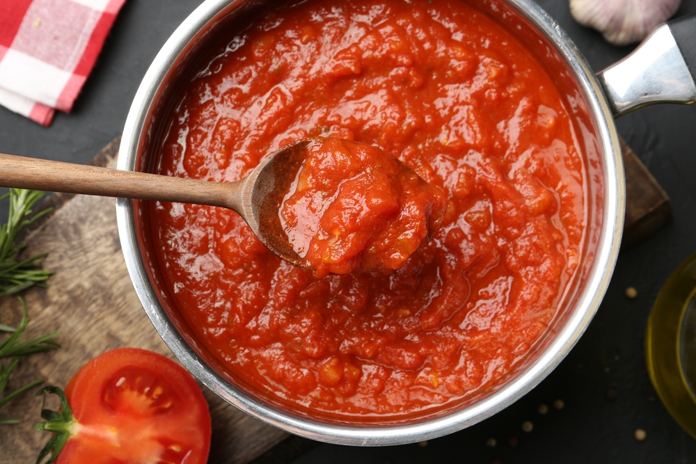 HomemadeTomatoSauceAndSpoonInPotOnDarkTable - welltica.dk - Vejen til et bedre liv