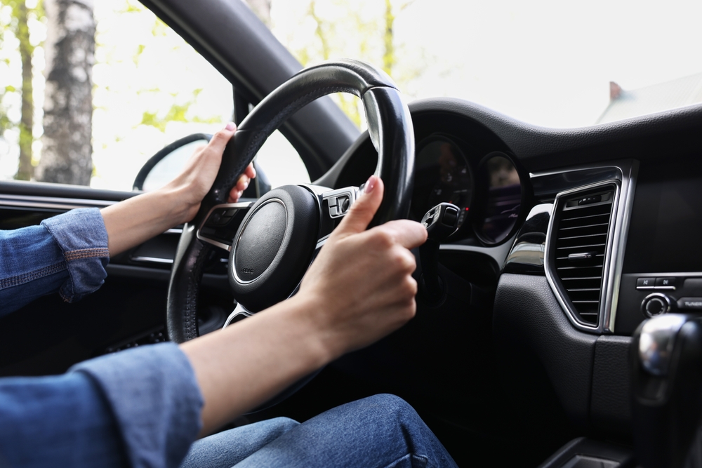 WomanHoldingSteeringWheelWhileDrivingHerCarCloseup - welltica.dk - Vejen til et bedre liv