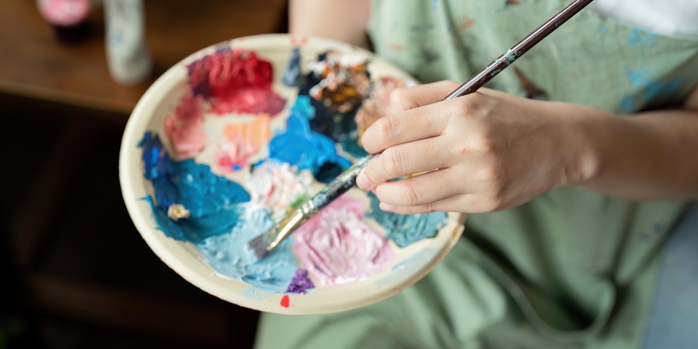 ArtistPaintingInWorkshopWithPaletteAndBrushCreatingColorful - welltica.dk - Vejen til et bedre liv