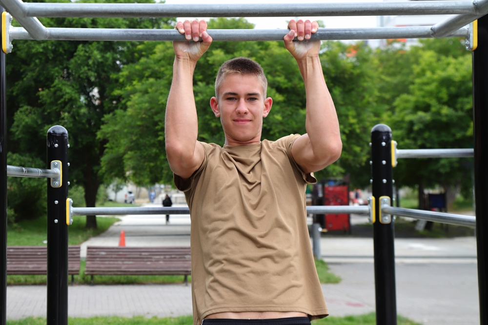 YoungBoyTeenagerDoingOutdoorSportWorkoutOnHorizontalBar - welltica.dk - Vejen til et bedre liv