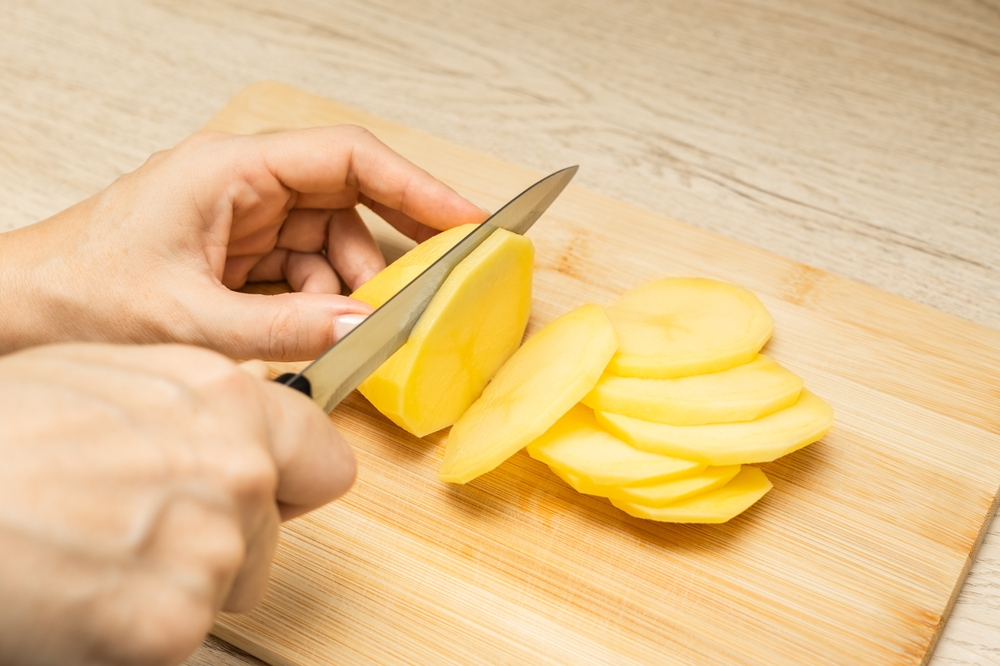 HousewifeCuttingPiecesOfFreshPotatoesClose-upCuttingPotatoesOn - welltica.dk - Vejen til et bedre liv