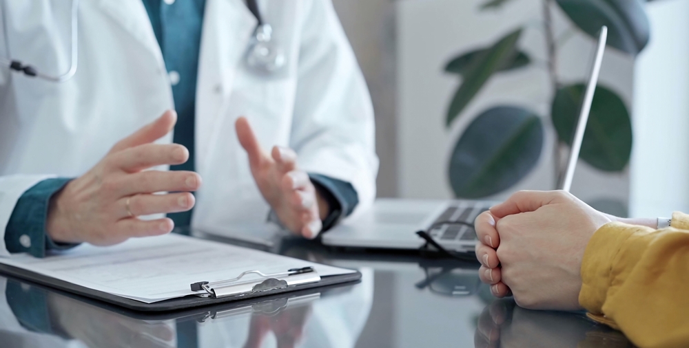 DoctorAndPatientConsultationInClinicPatientListensAttentivelyAs - welltica.dk - Vejen til et bedre liv