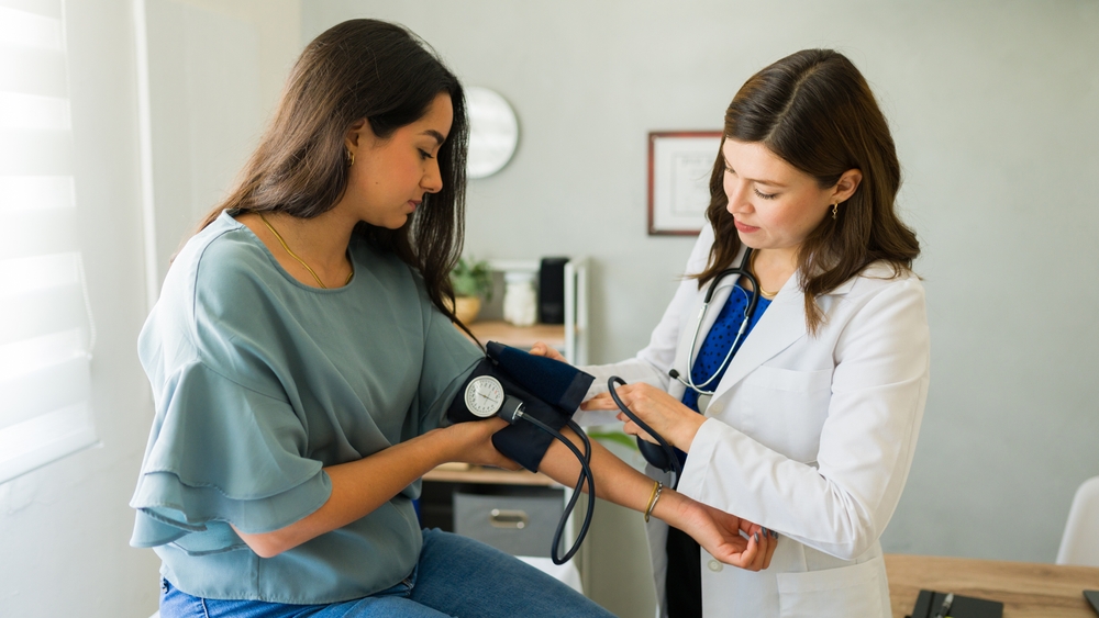 YoungFemalePatientHavingHerBloodPressureCheckedByA - welltica.dk - Vejen til et bedre liv