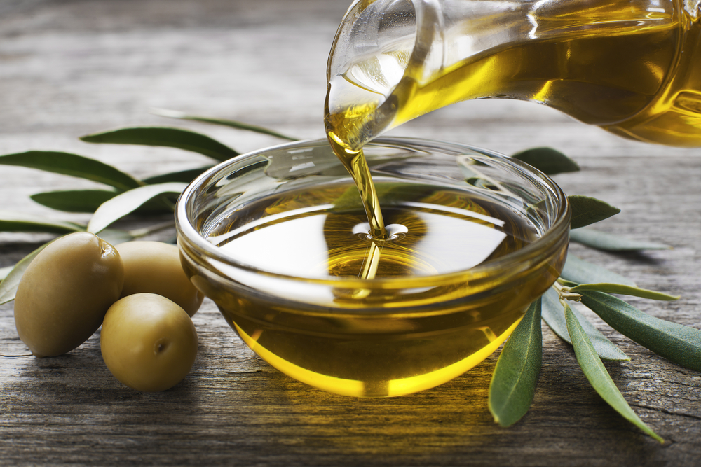 BottlePouringVirginOliveOilInABowlCloseUp - welltica.dk - Vejen til et bedre liv