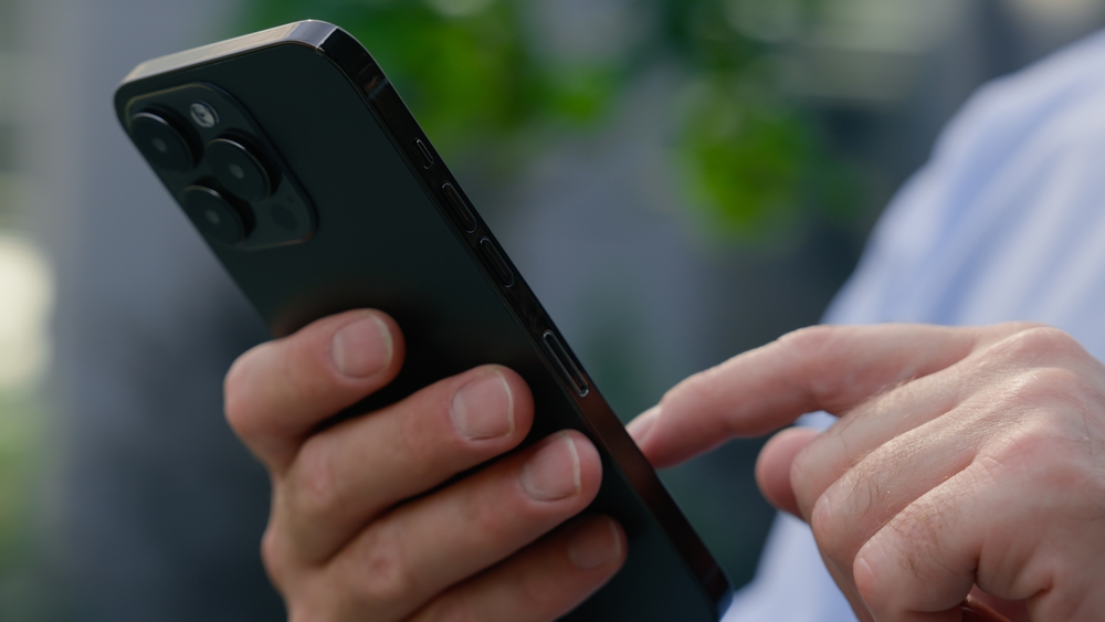 CloseUpCaucasianMaleHandsArmsHoldingMobilePhoneScrolling - welltica.dk - Vejen til et bedre liv