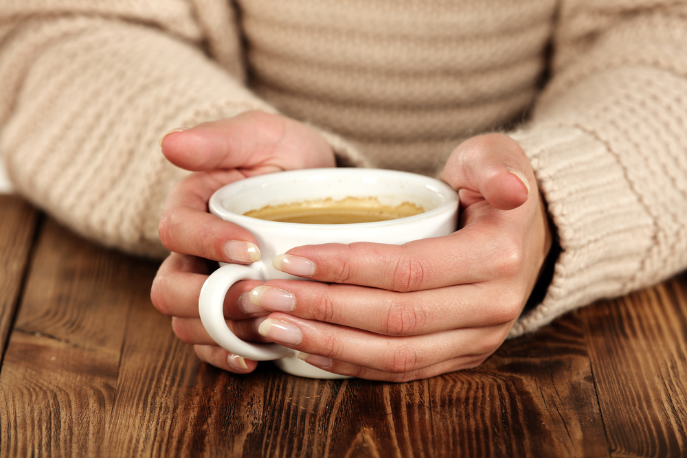 WomanInBrownColorWhiteWallAndCoffeeWhiteColor - welltica.dk - Vejen til et bedre liv