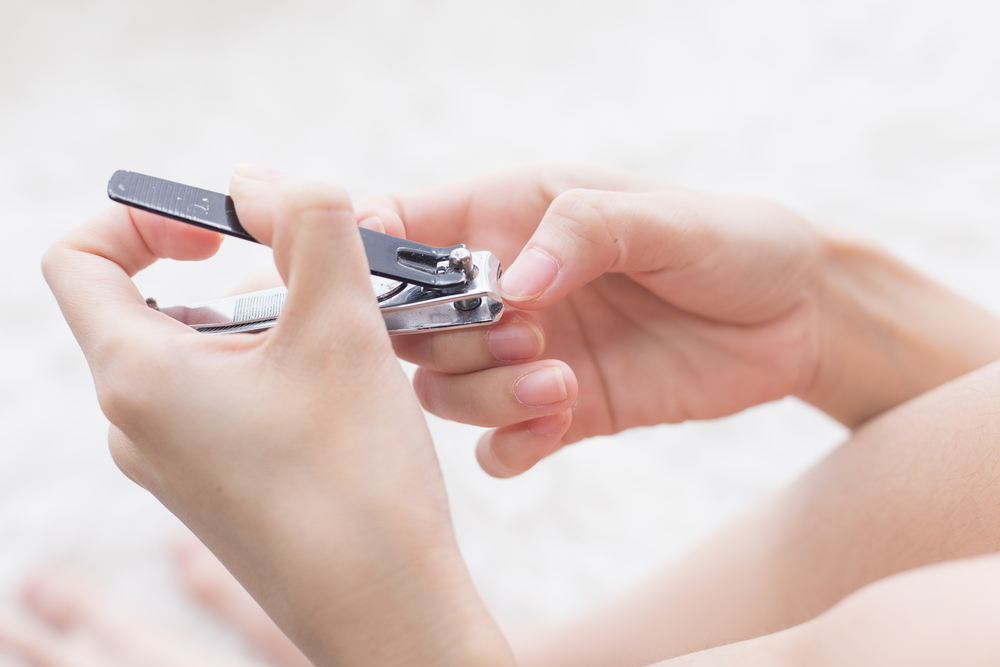 CloseUpOfTheFemaleHandsWhileCuttingFingernailsOr - welltica.dk - Vejen til et bedre liv