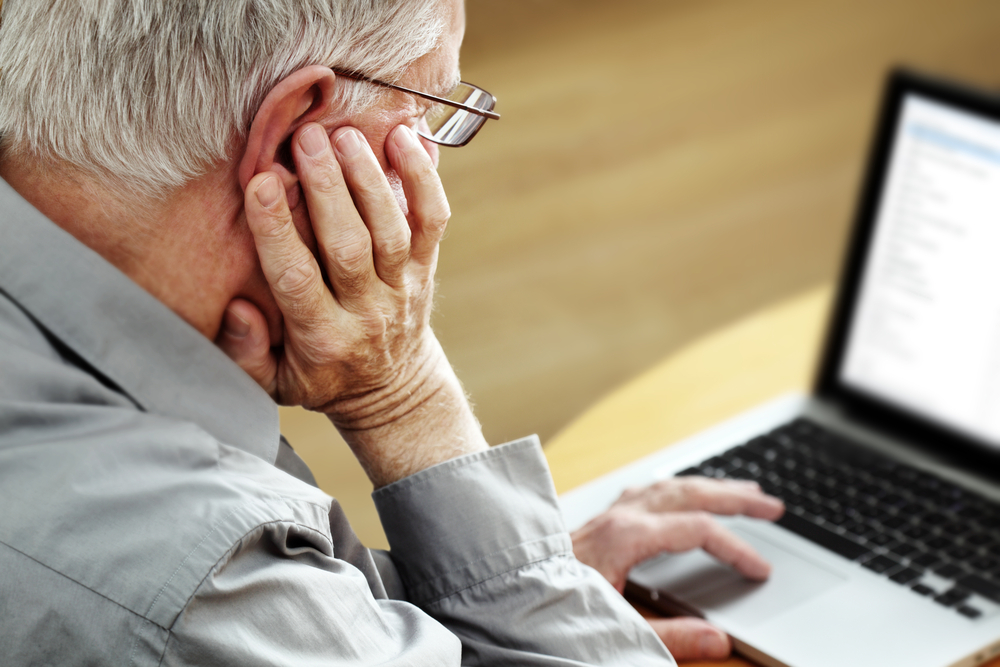 SeniorWithLaptopFocusOnHand - welltica.dk - Vejen til et bedre liv