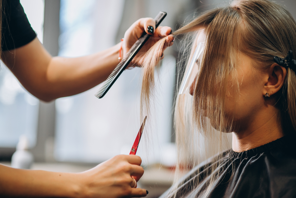 HairdresserCutsHairByScissorsBeautifulBlondeGirl - welltica.dk - Vejen til et bedre liv