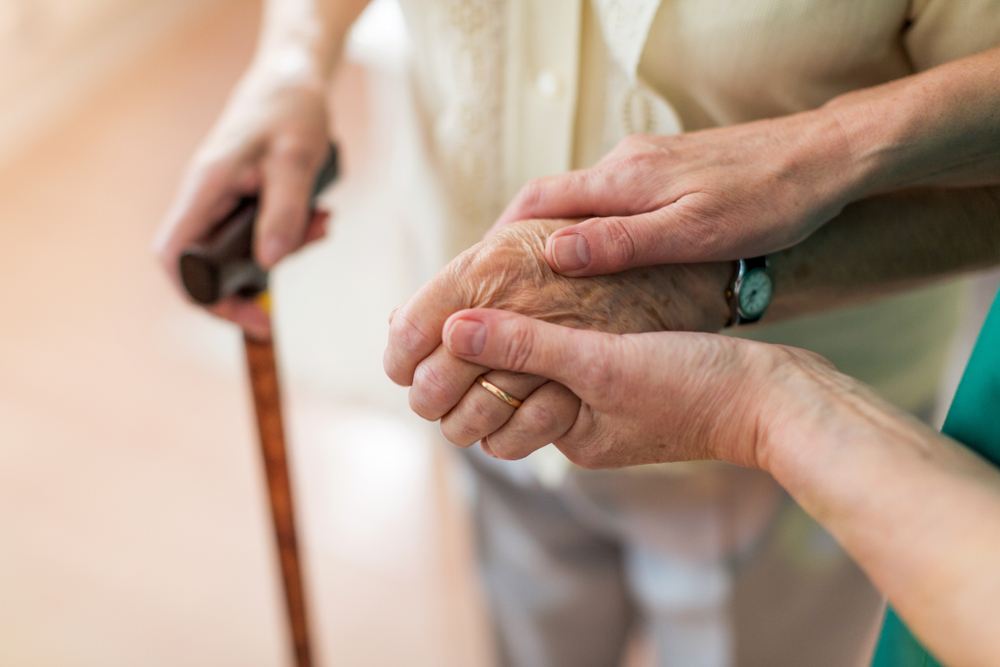NurseConsolingHerElderlyPatientByHoldingHerHands - welltica.dk - Vejen til et bedre liv