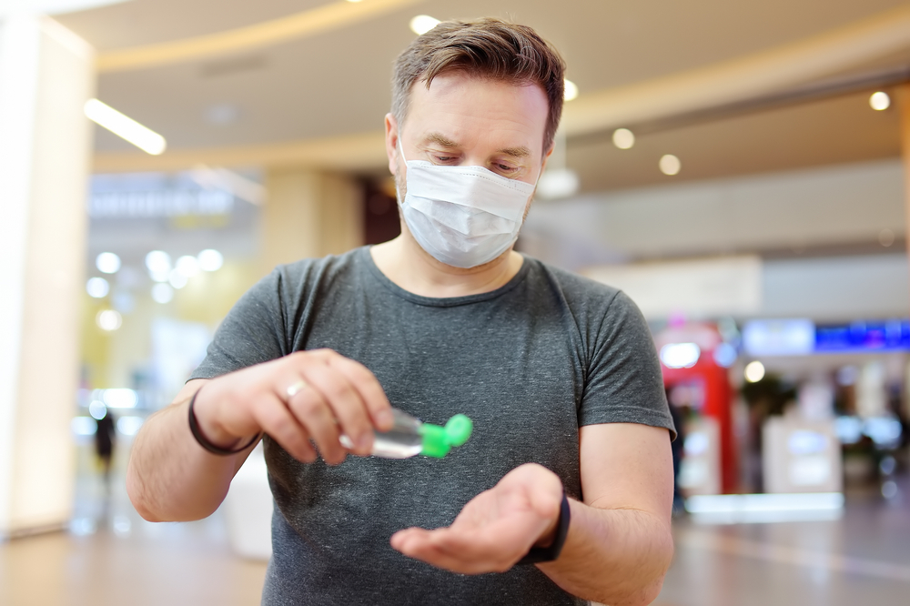 ManWearingDisposableMedicalFaceMaskMakesDisinfectionOfHands - welltica.dk - Vejen til et bedre liv