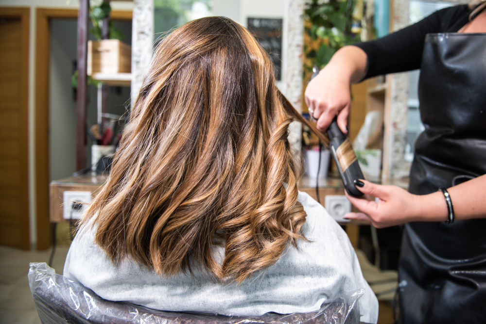 HairdresserDoingCurlsToAClientInTheHairdresser - welltica.dk - Vejen til et bedre liv