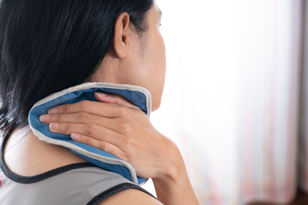 WomanPuttingAnIcePackOnHerNeckPain - welltica.dk - Vejen til et bedre liv