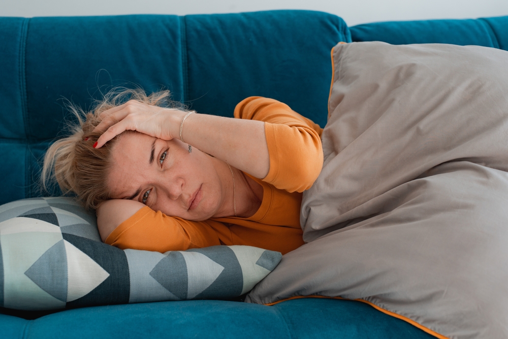 DepressedMatureWomanLyingSofaWithHerArmsAroundHerself - welltica.dk - Vejen til et bedre liv