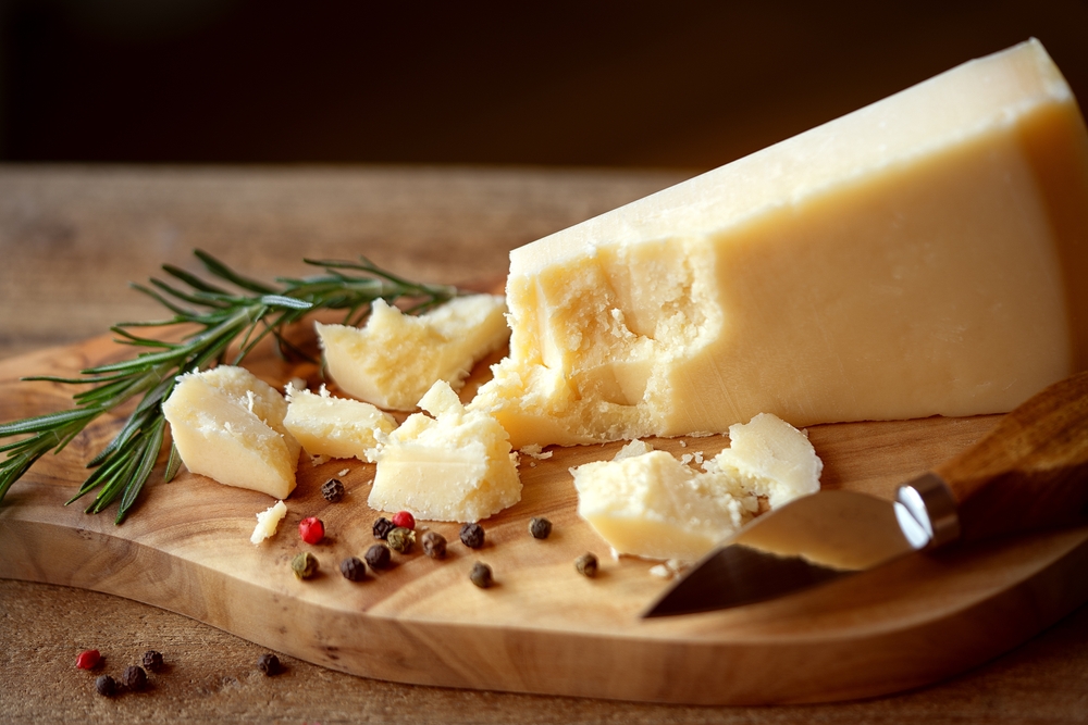 ParmigianoReggianoCheesePortionWithCrumbsOnCuttingBoardOrtion - welltica.dk - Vejen til et bedre liv