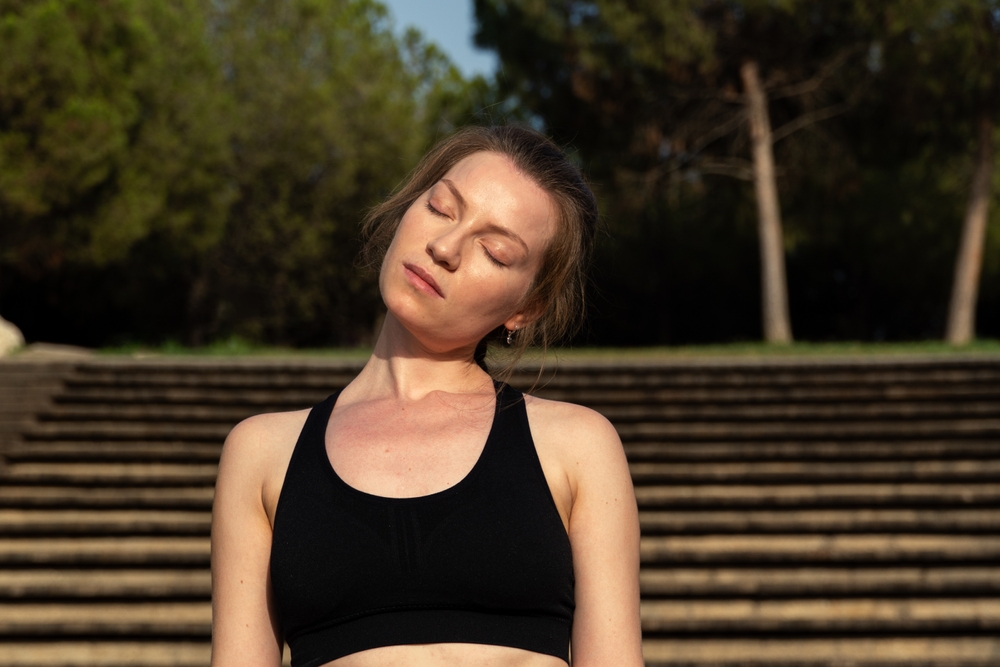 ARed-hairedWomanIsSeenPracticingHeadRotationStretchesIn - welltica.dk - Vejen til et bedre liv