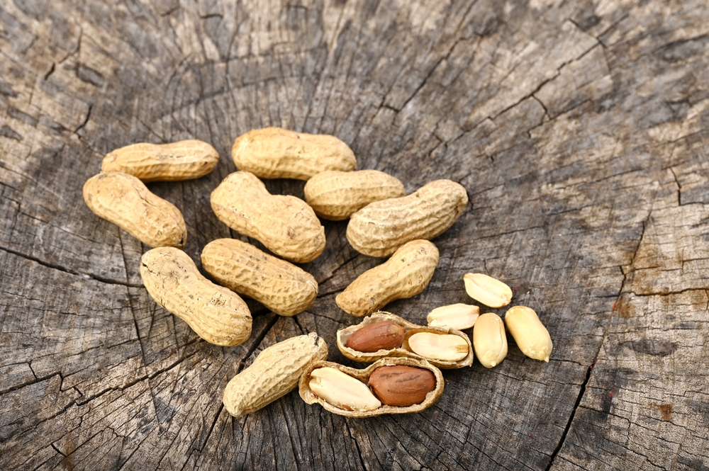 PeanutsOnAnOldWoodenBoardWholeAndShelledNuts - welltica.dk - Vejen til et bedre liv