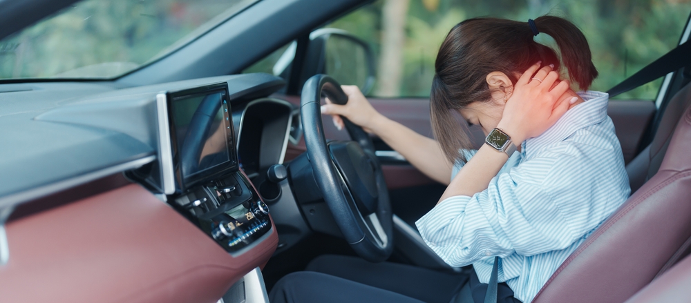 WomanWithHerShoulderAndNeckSprainWhileDrivingCar - welltica.dk - Vejen til et bedre liv
