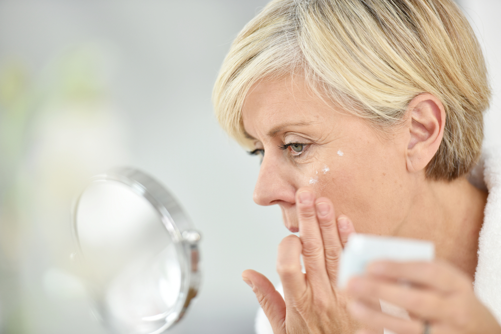 SeniorWomanInBathroomApplyingAnti-agingLotion - welltica.dk - Vejen til et bedre liv