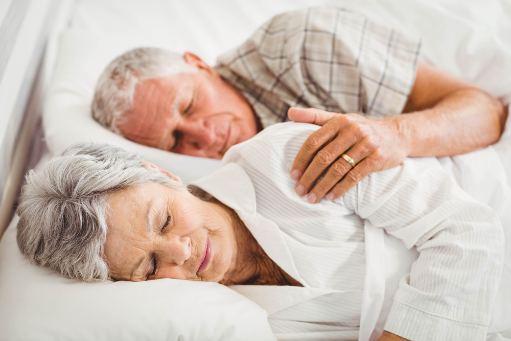 SeniorCoupleSleepingOnBedInBedroom - welltica.dk - Vejen til et bedre liv