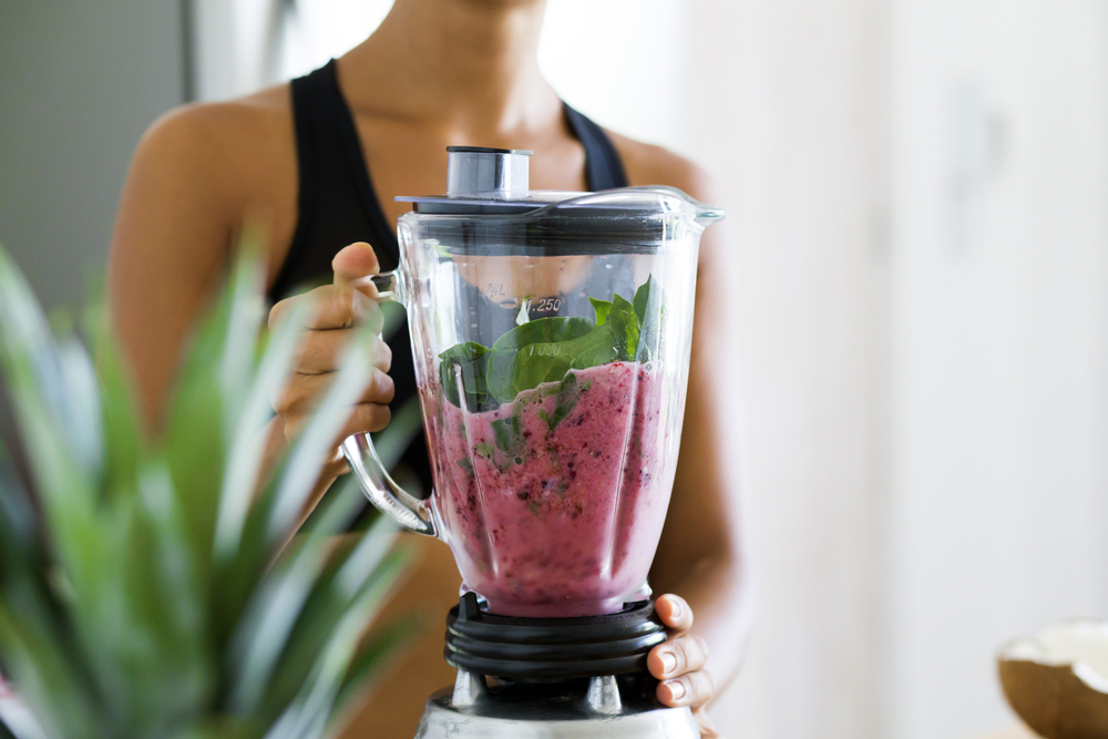 WomanBlendingSpinachBerriesBananasAndAlmondMilkToMake - welltica.dk - Vejen til et bedre liv