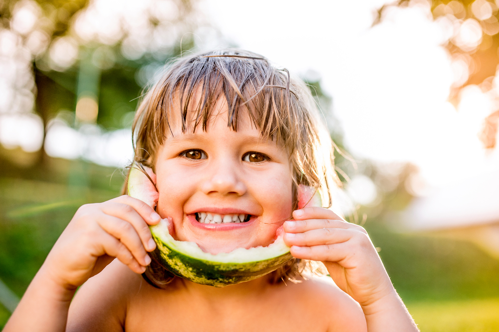 CuteLittleGirlEatingWatermelonInSunnySummerGarden - welltica.dk - Vejen til et bedre liv