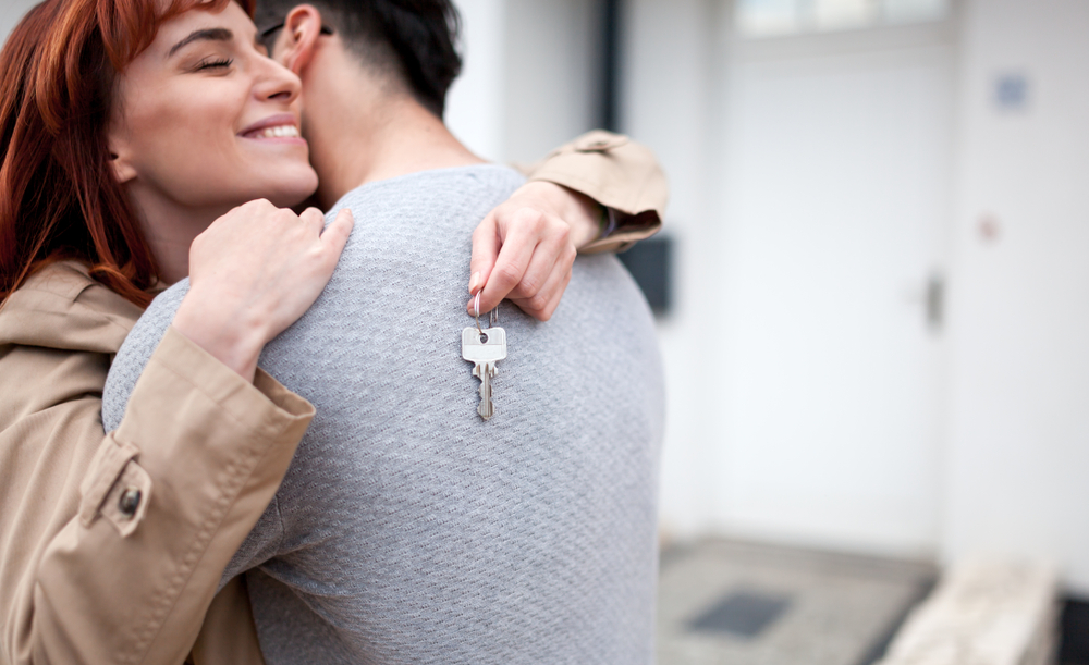 HappyCoupleWithKeysHuggingInFrontOfTheirNew - welltica.dk - Vejen til et bedre liv