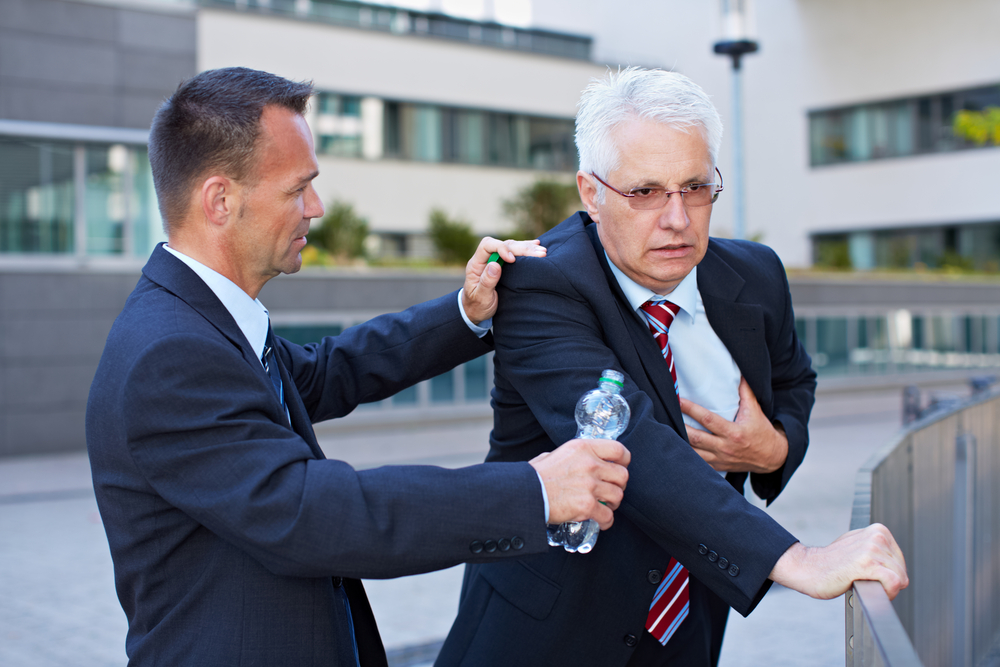 BusinessManHelpingSeniorWithHeartAttackWithABottle - welltica.dk - Vejen til et bedre liv