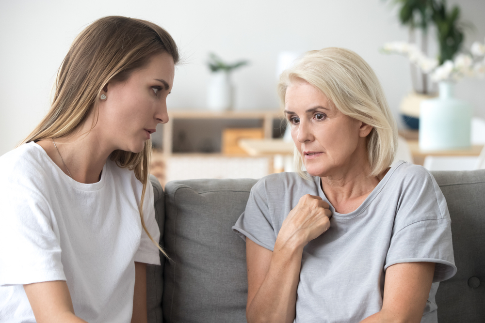 ConcernedAgedMotherAndAdultDaughterSitOnCouchHaving - welltica.dk - Vejen til et bedre liv