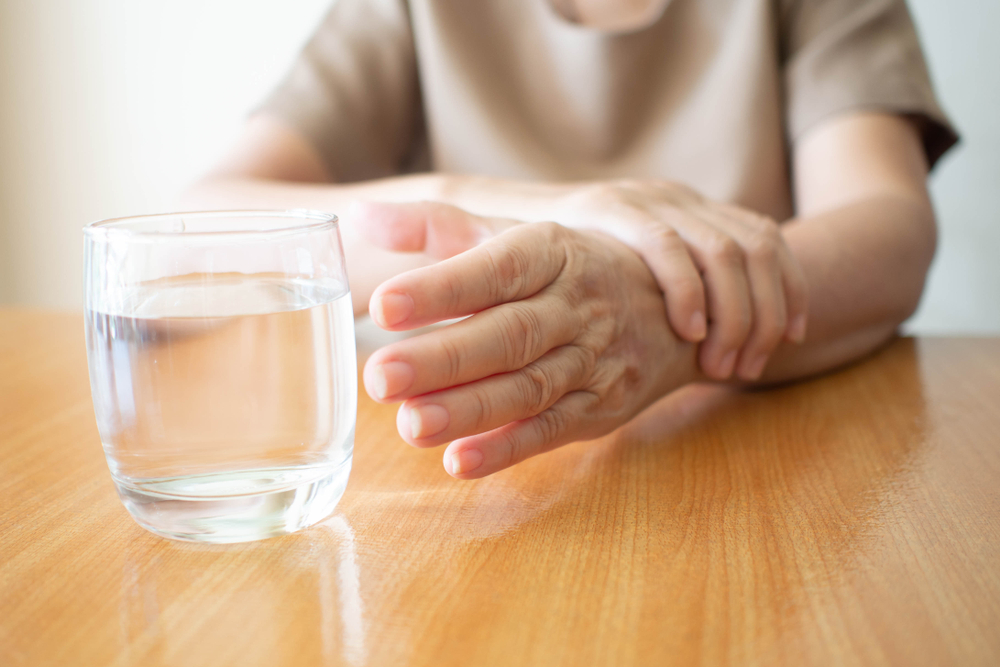 ElderlyWomanHandsWTremorSymptomReachingOutForA - welltica.dk - Vejen til et bedre liv