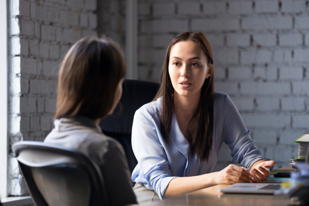 SeriousProfessionalFemaleAdvisorConsultingClientAtMeetingTalkingHaving - welltica.dk - Vejen til et bedre liv