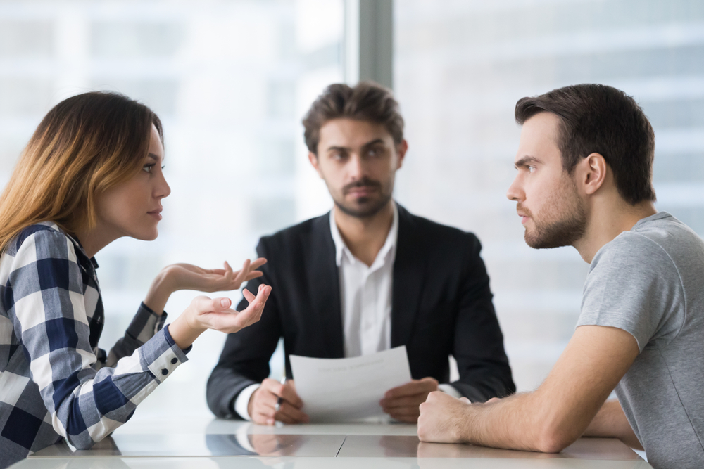 AnnoyedUnhappyMarriedCoupleArguingInLawyersOfficeGetDivorced - welltica.dk - Vejen til et bedre liv